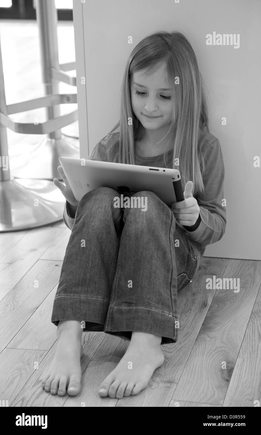 Giovane ragazza che gioca su un iPad di Apple computer tablet Foto Stock