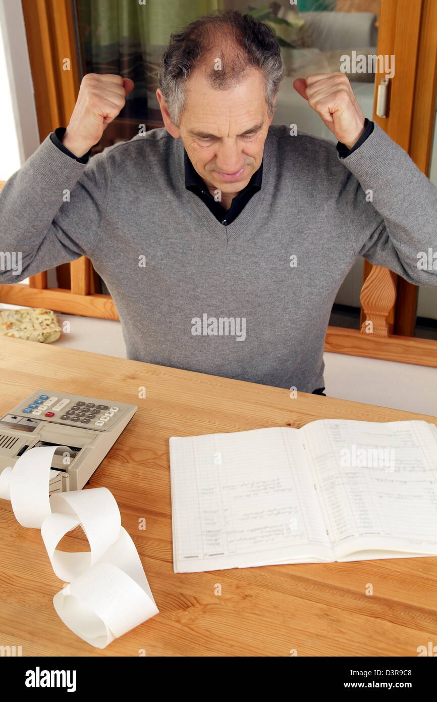 L'uomo anziano con la calcolatrice e il libretto Foto Stock