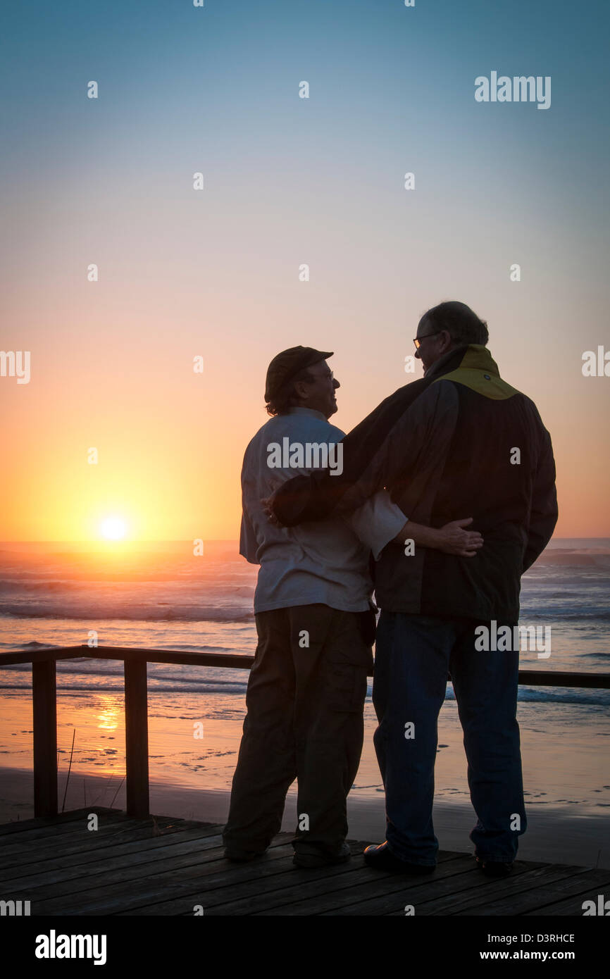 Coppia gay al tramonto sul ponte di casa sulla spiaggia a Yachats sulla centrale di Oregon Coast. Foto Stock