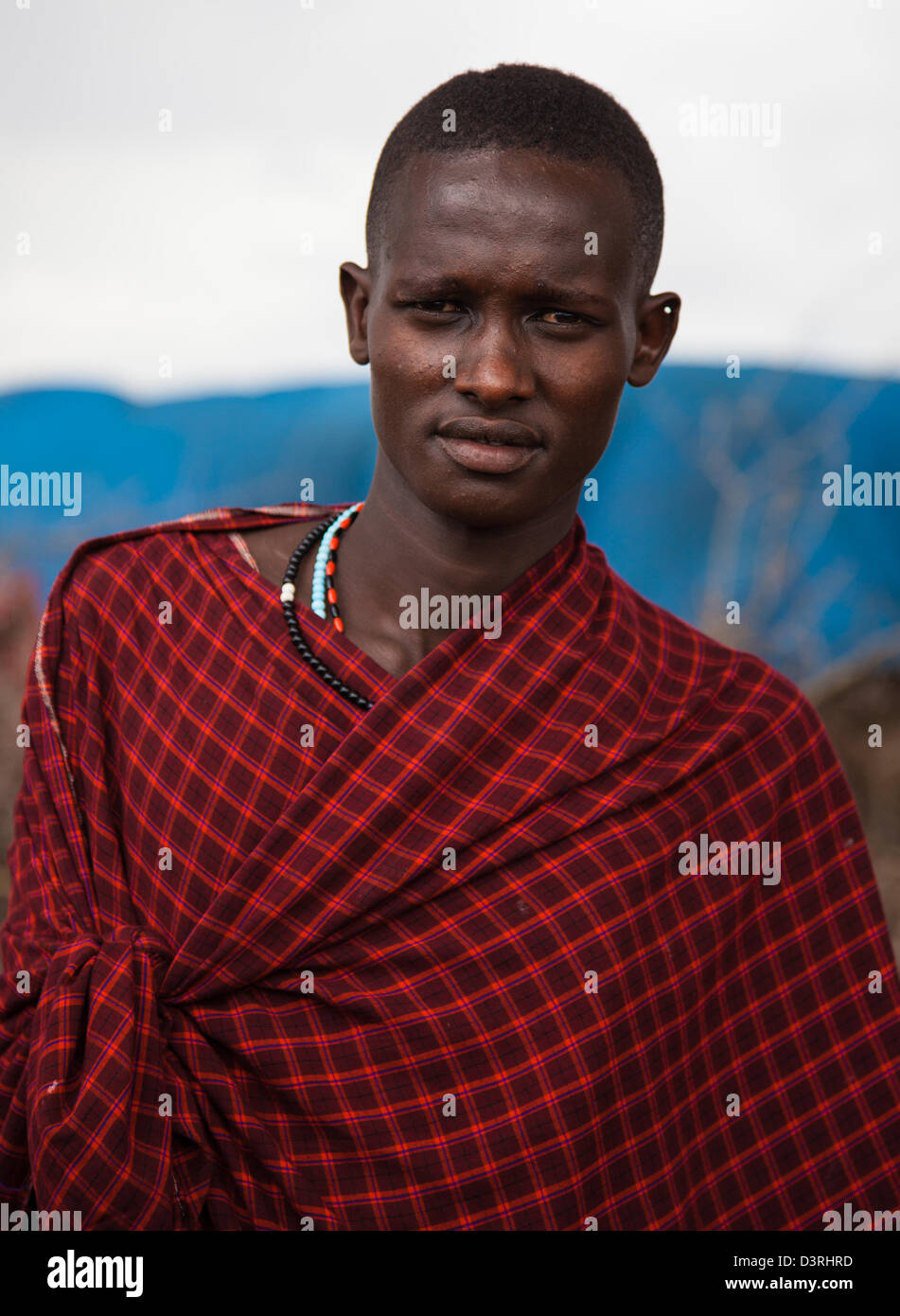 Un guerriero Masai vestito in abito tradizionale. In un boma fuori dal cratere di Ngorongoro. Tanzania Foto Stock