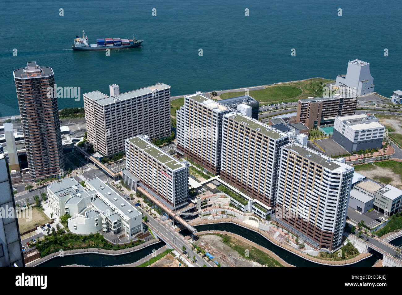 Vista aerea di Osaka's Sakishima Nanko isola in esteri zona di accesso (FAZ) con contenitore freighter passa alto edificio di appartamenti Foto Stock