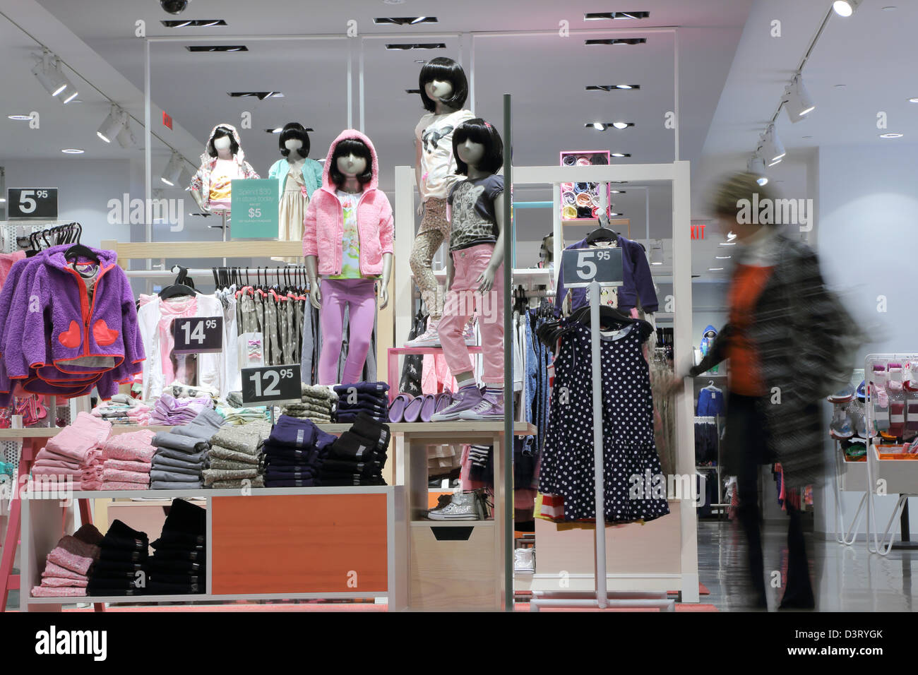 Shopper scegliendo abito bambino negozio di abbigliamento Foto Stock