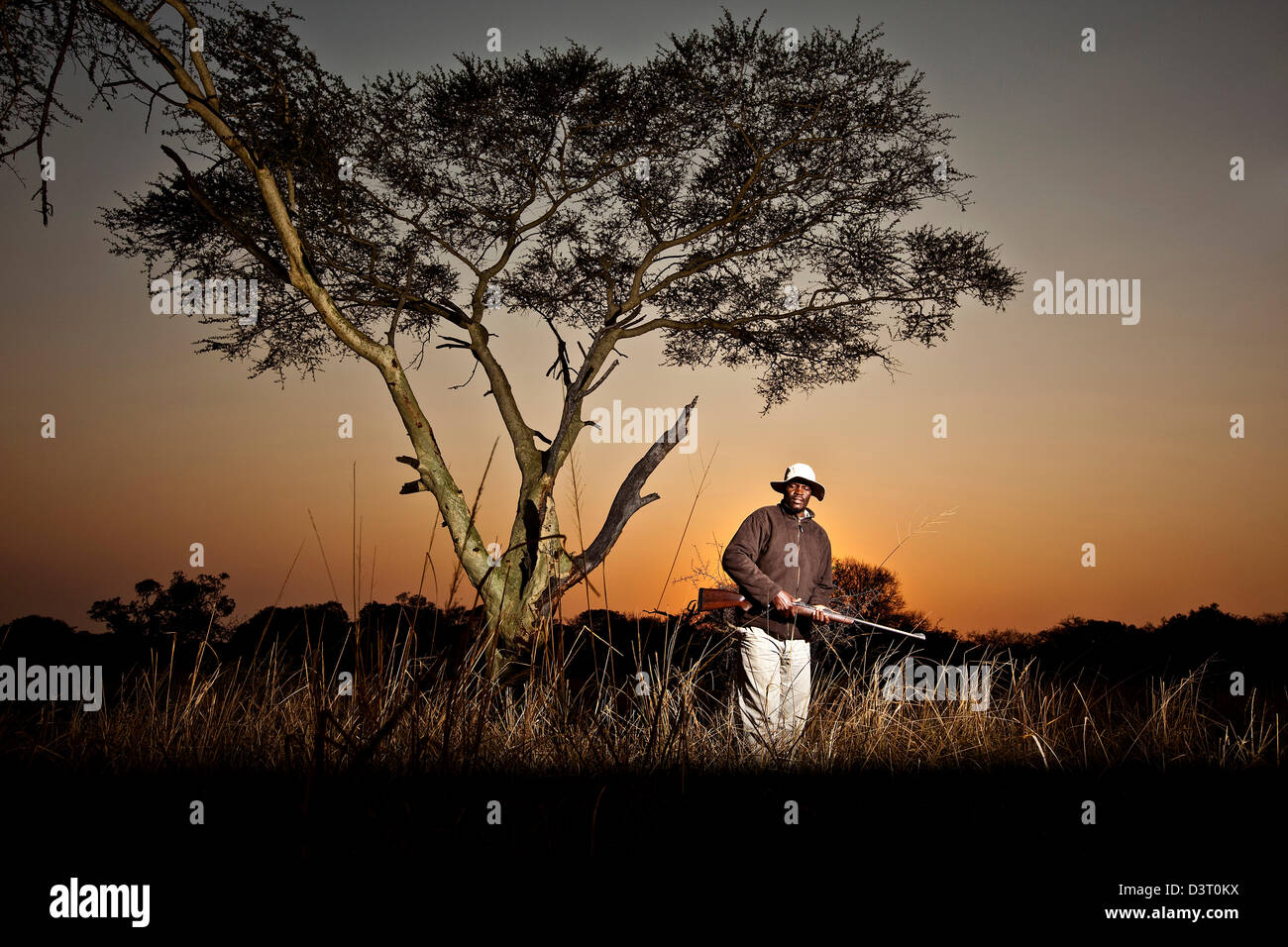 Safari ranger si erge con un fucile in Phinda Game Reserve, Sud Africa Foto Stock