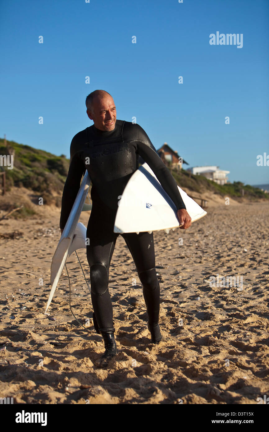 Surfer con tavola rotta sulla spiaggia, Jeffreys Bay, Oceano Indiano, Sud Africa Foto Stock