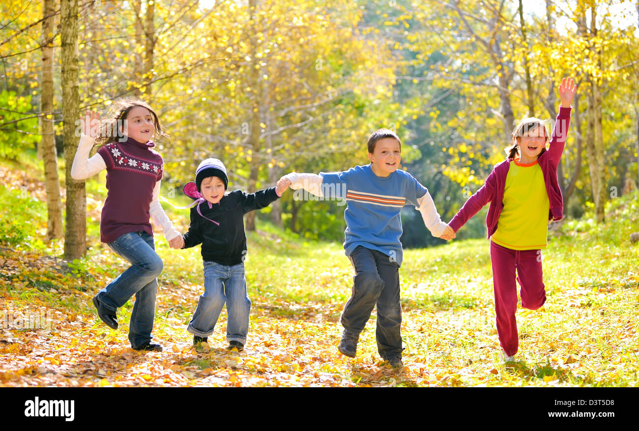 Contenti i bambini e foglie di autunno Foto Stock