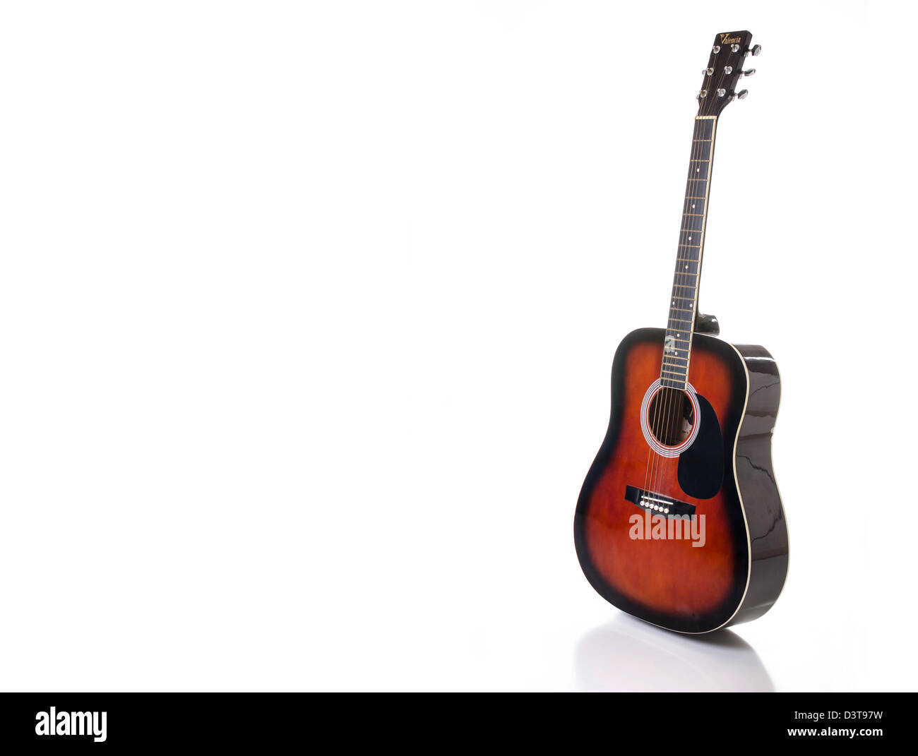 Una chitarra acustica set contro uno sfondo bianco e riflettendo in superficie al di sotto. Foto Stock