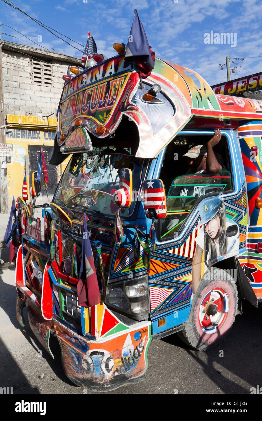 Tap-tocca gli autobus che passa attraverso il centro cittadino di Port-au-Prince. Tap-tap veicoli servono come i mezzi di trasporto pubblici in Haiti. Foto Stock