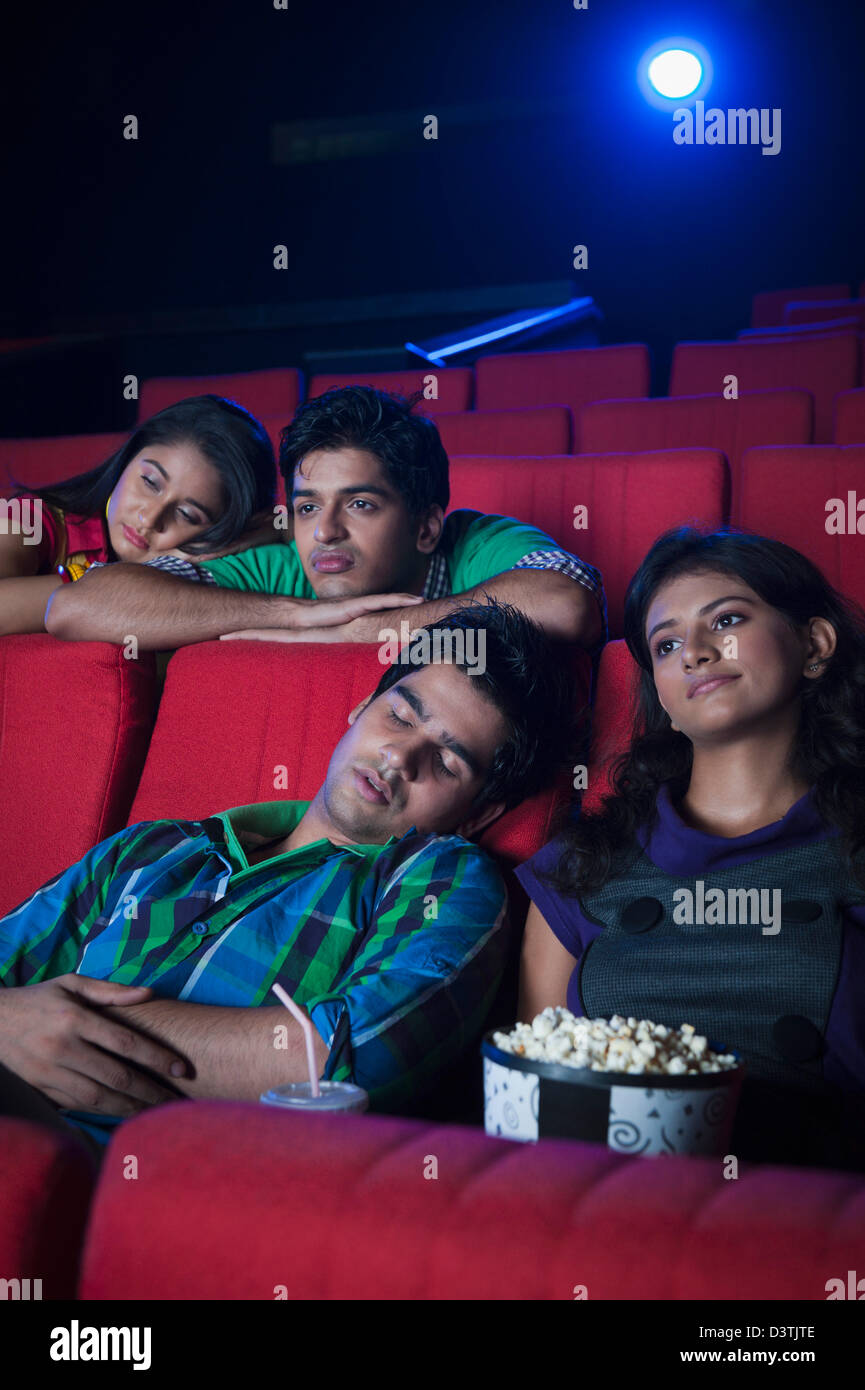 Sensazione di giovani annoiati durante la visione di un film in una sala cinematografica Foto Stock
