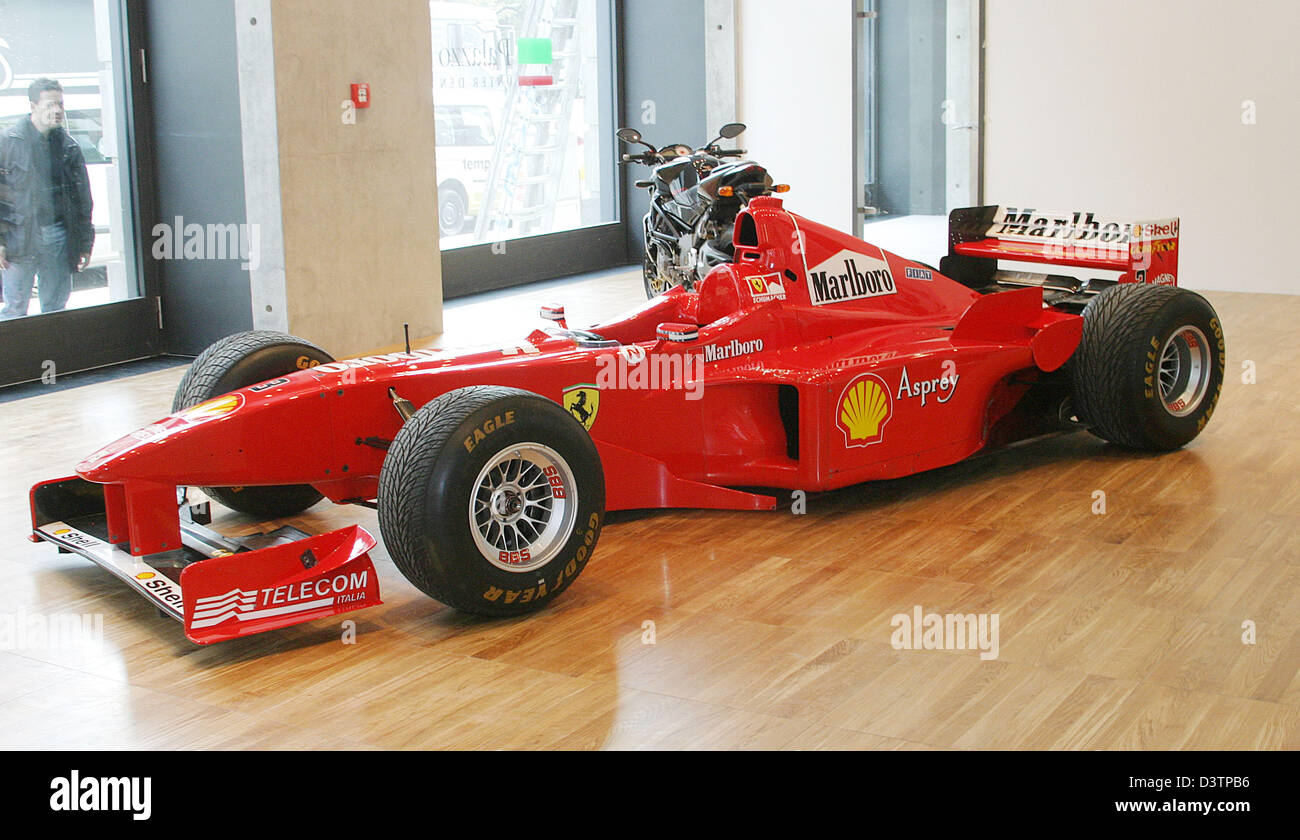 Un uomo prende un guardare attraverso la finestra in una Ferrari racing car nello showroom di Palazzo Italia a Berlino, Germania, Thurdsay, 19 ottobre 2006. Il Palazzo Italia, uno stabilimento per la promozione dell'economia italiana sul mercato tedesco, inaugurato il 19 ottobre in Berlin Unter den Linden. Foto: Xamax Foto Stock