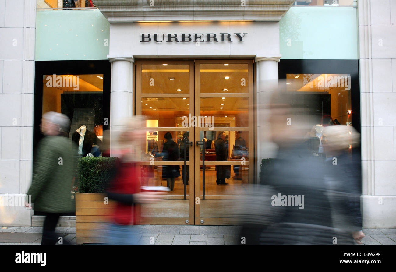 I pedoni a piedi oltre la finestra di visualizzazione del marchio di moda Burberry a boulevard Königsallee a Duesseldorf in Germania, martedì 05 dicembre 2006. Foto: Roland Weihrauch Foto Stock