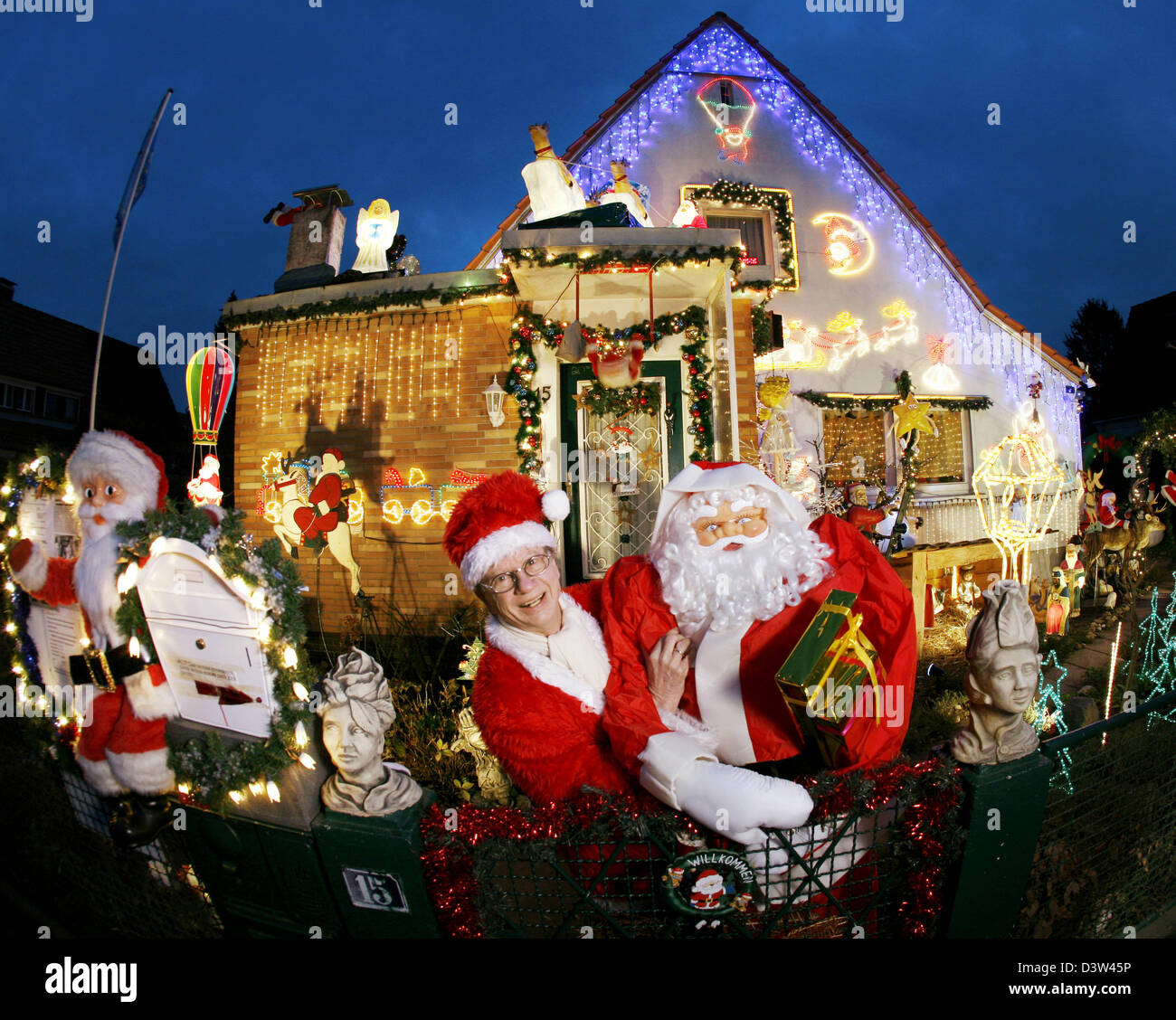 Vestiti da Babbo Natale Bernhard Nermerich (L) si trova di fronte la sua casa decorata in tutto con luci e decorazioni di Natale a Kelheim, Taunus, Germania, lunedì 18 dicembre 2006. Già nel mese di agosto la ex atleta e Olympia partecipante e sua moglie ha iniziato a mettere il secondo Nermerich 88,888 lampade. Foto: Frank Rumpenhorst Foto Stock
