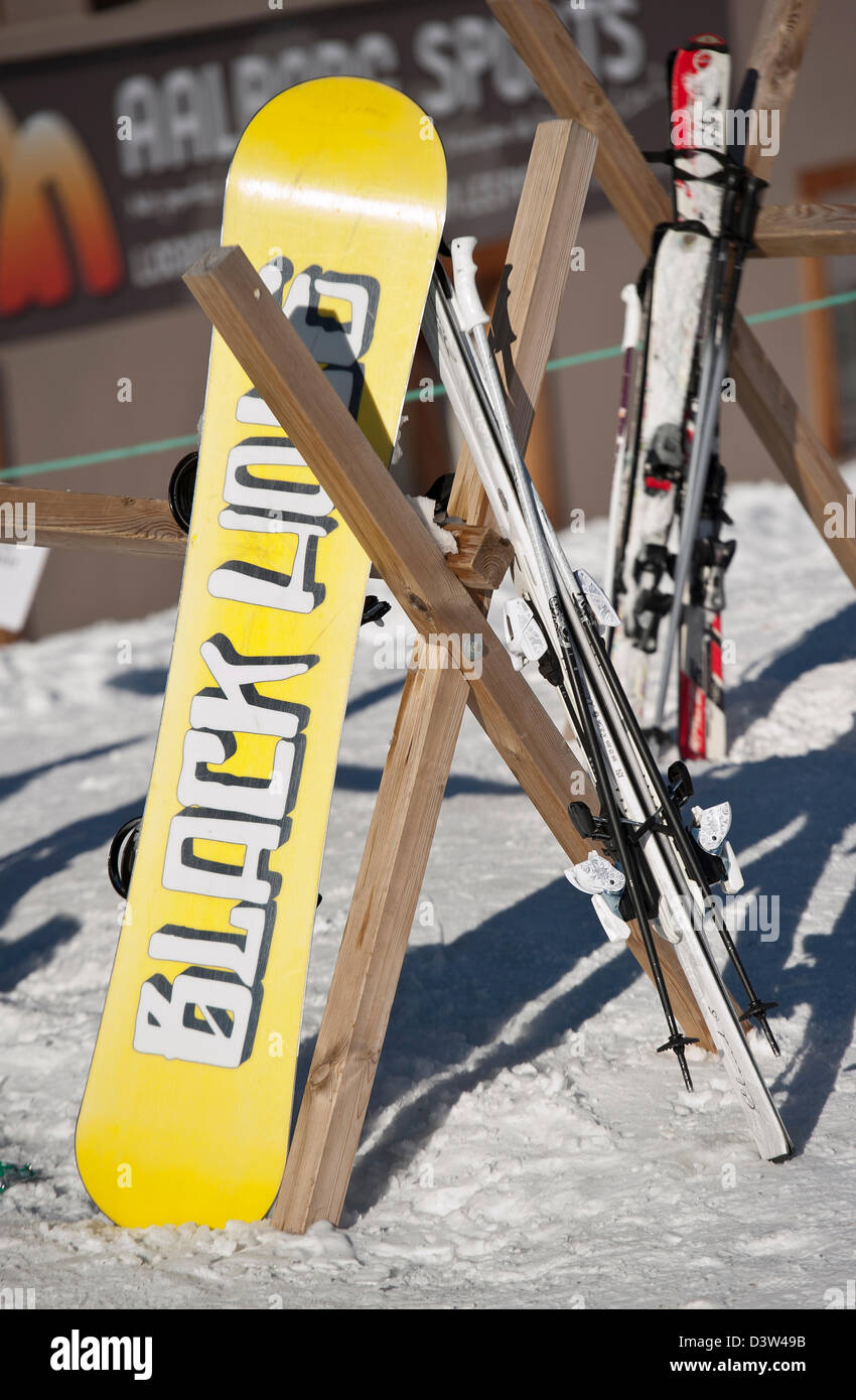 Snowboard e sci il resto in un rack al di fuori di un bar nelle Alpi francesi Foto Stock