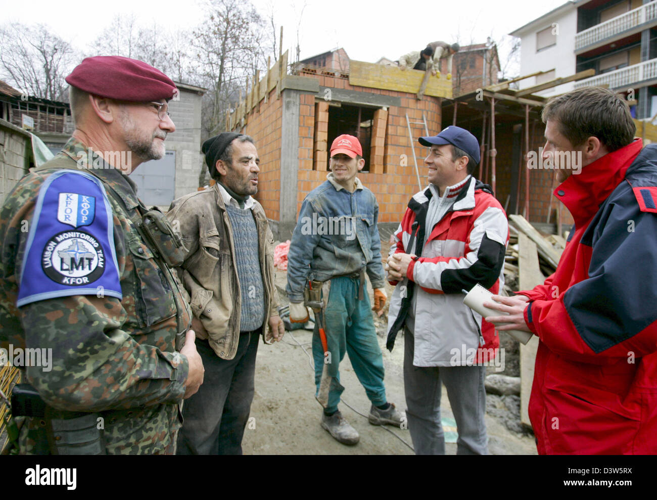 Forze armate tedesche giustificano Officer Classe I Detlef Kerkow (L) del Liaison Team di monitoraggio (LMT) parla con lavoratori edili in Mushnikovo, Kosovo, 13 dicembre 2006. Il villaggio si trova a nord di Prizren è uno dei molti villaggi pattugliato da LMT che si prende cura dei residenti" questioni. Foto: Matthias Schrader Foto Stock
