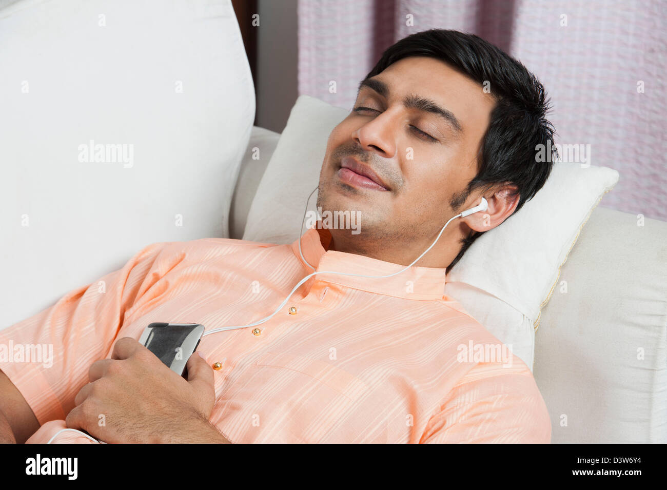 Uomo in Bengali ascolto di un lettore mp3 Foto Stock