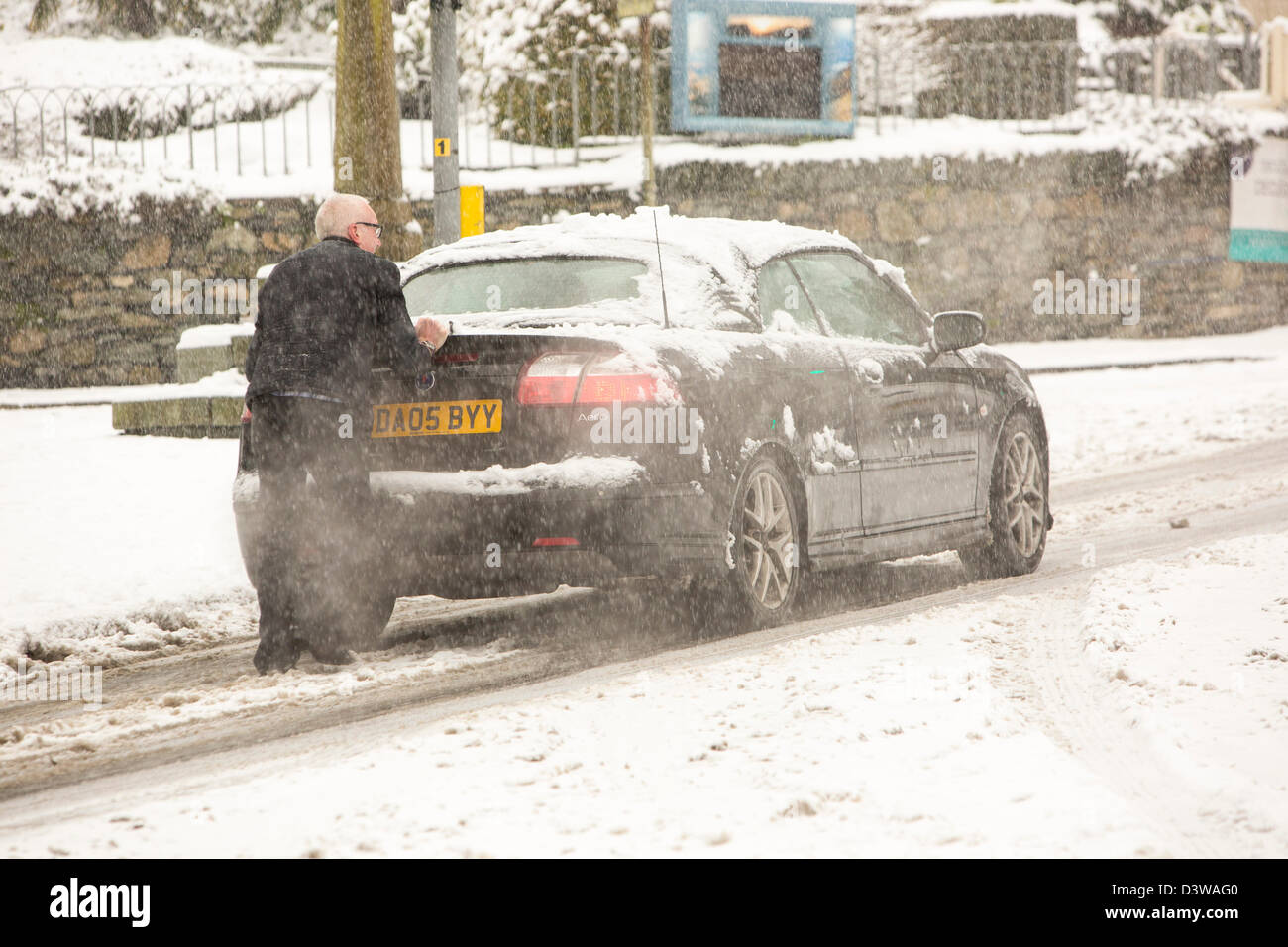 Una vettura che viene spinto attraverso la neve pesante a Ambleside, Lake District, UK. Foto Stock