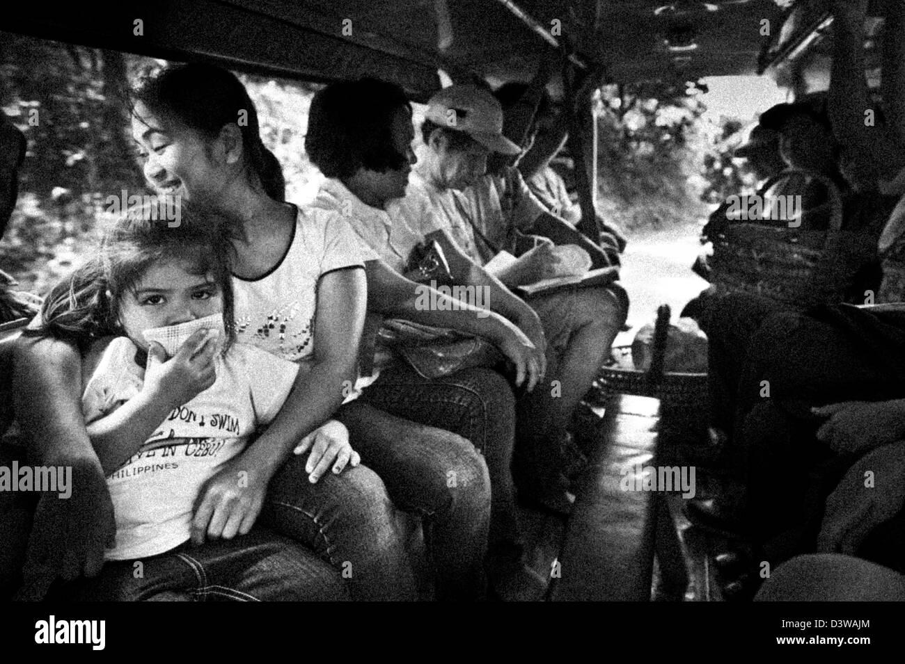 Persone che viaggiano all'interno di un jeepney, il più comune mezzo di trasporto di massa nelle Filippine, in Asia Foto Stock