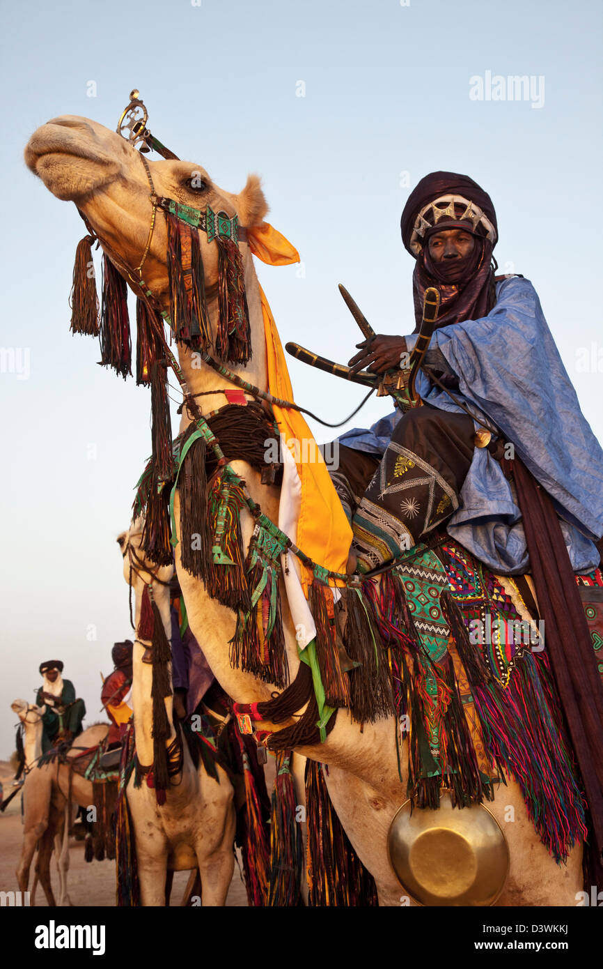 Il nomade Wodaabe Cavalca un cammello durante il festival di Gerewol vicino Ingal, Niger Foto Stock