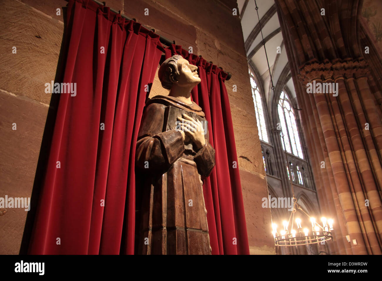 Pregando monaco con caduta di rosso tenda a Strasburgo, Alsazia, Francia Foto Stock