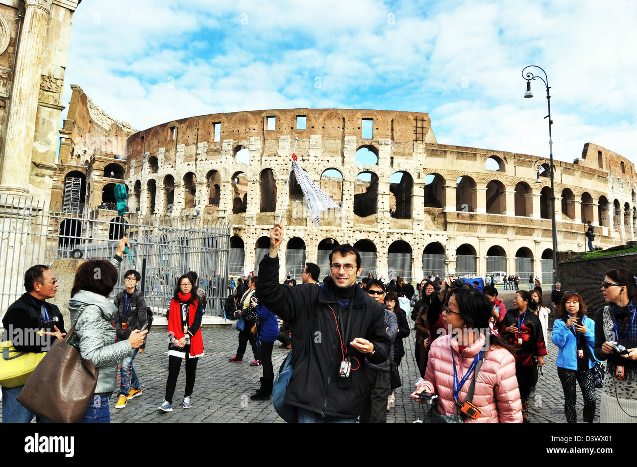 I turisti giapponesi vengono arrotondati da una guida locale, Colosseo Roma Italia Foto Stock