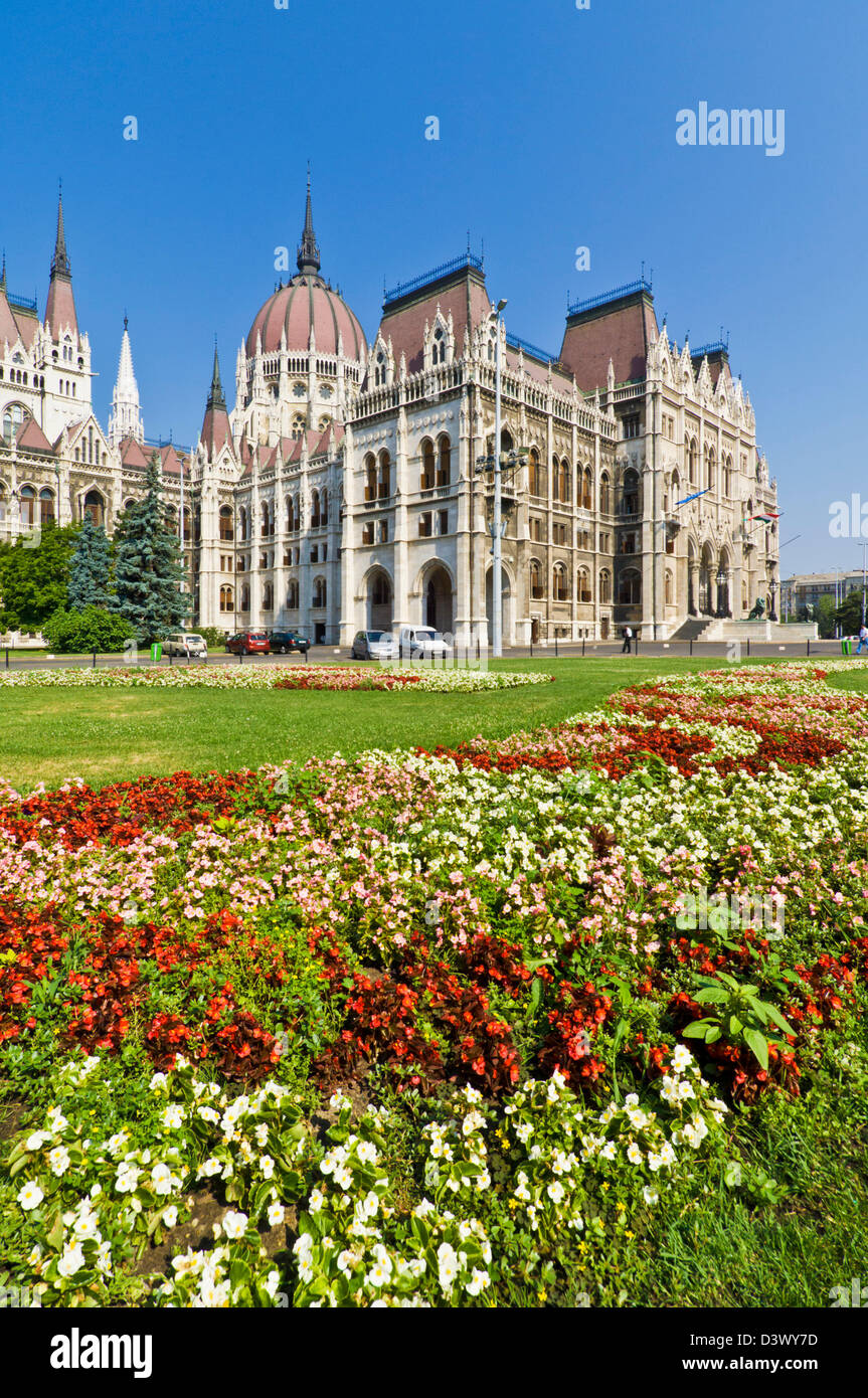 Letti di fiori nella parte anteriore del neo-gotico del parlamento ungherese edificio, progettato da Imre Steindl, Budapest, Ungheria, Europa UE Foto Stock