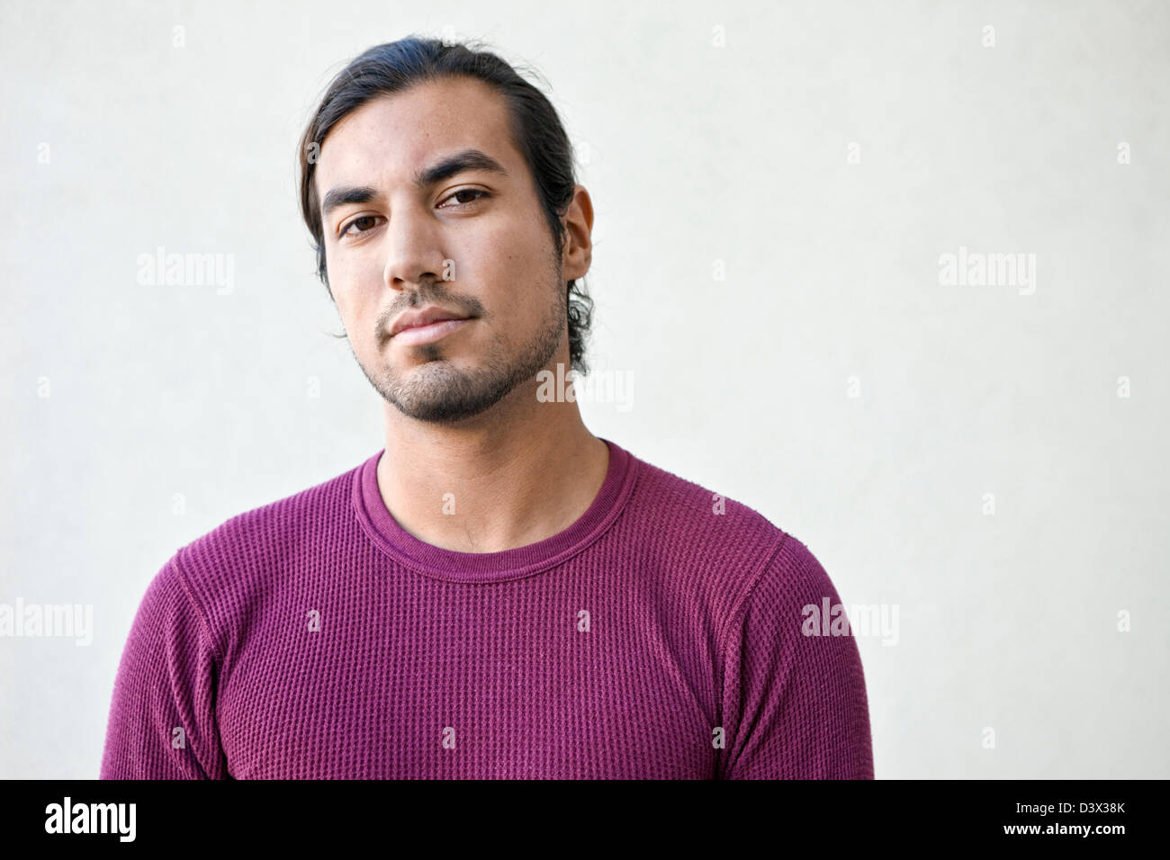 Ingenui e fiduciosi Ritratto di giovane dai lunghi capelli Mexican-American adulto maschio Foto Stock
