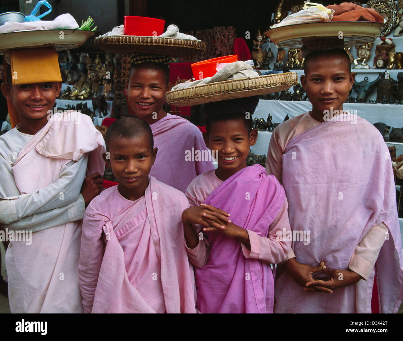 I monaci cestello di trasporto sulla testa a Nyaung Oo Mercato, Bagan, Myanmar Foto Stock