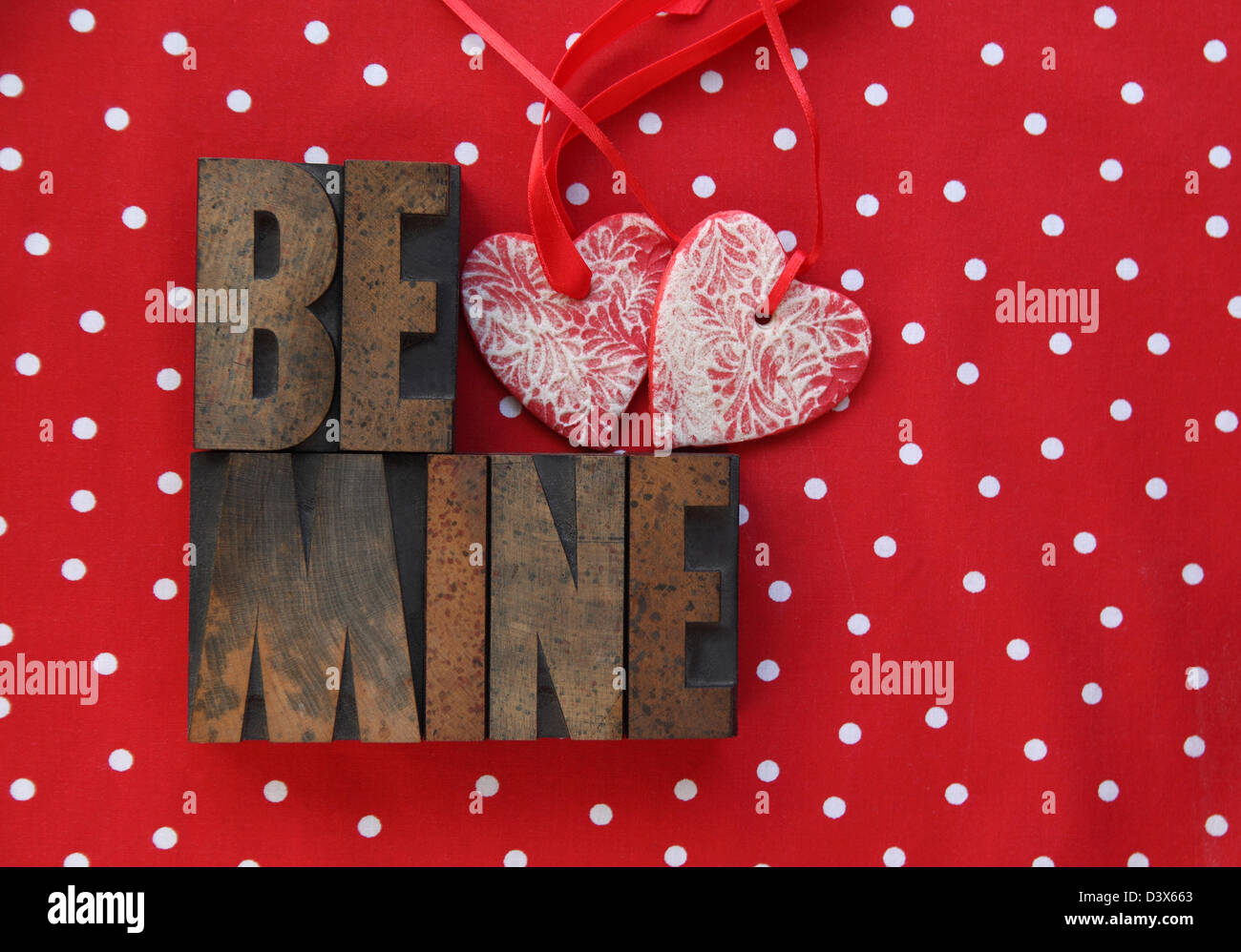 Le parole 'essere mio' con pasta di sale cuore ornamenti su una polka dot sfondo Foto Stock