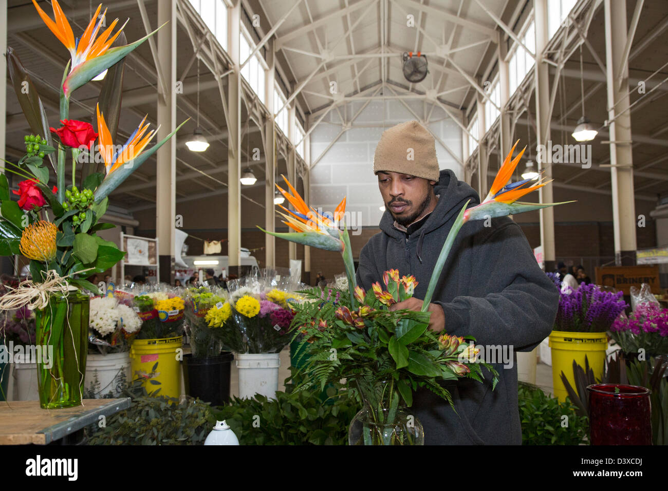 Detroit, Michigan - un lavoratore organizza fiori per la vendita in uno stand al Mercato Orientale, la città principale del mercato degli agricoltori. Foto Stock