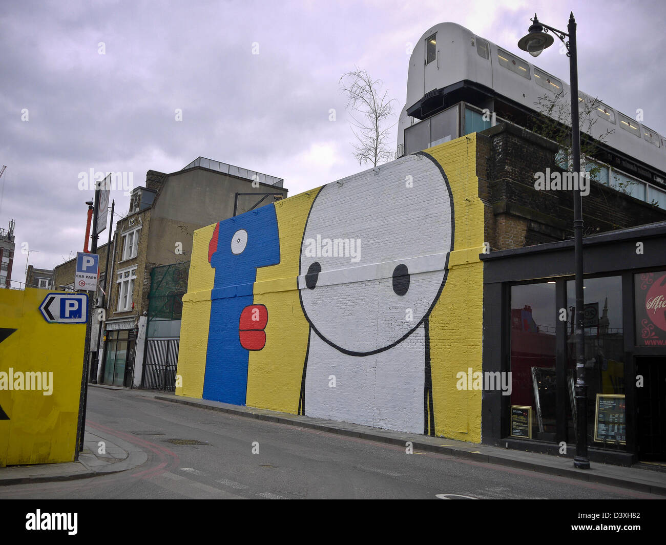 Arte di strada dagli artisti Stik e Thierry Noir in Shoreditch, Londra. Foto Stock