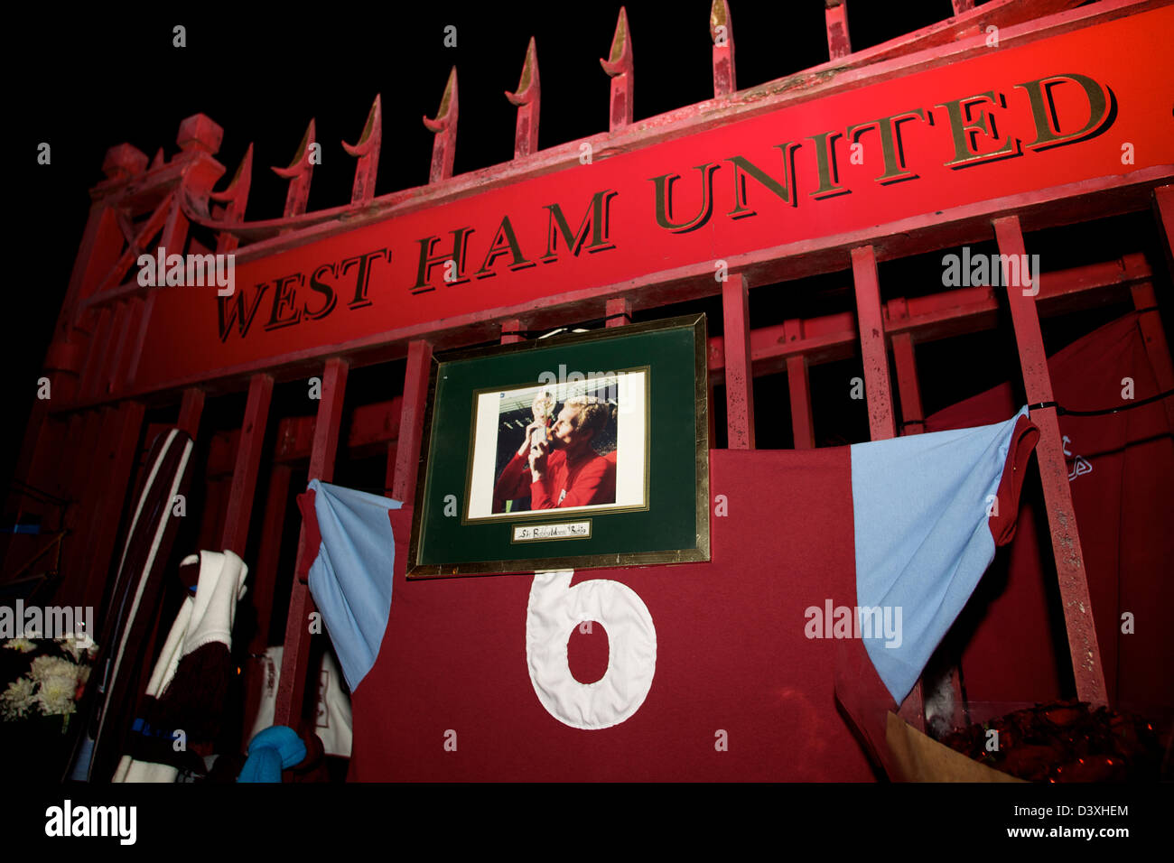 Le bandiere della ventola, sciarpe e foto presso la porta principale per il club di massa. West Ham v Tottenham Hotspur gioco su Lunedì 25 Febbraio ricorre il ventesimo anniversario del passaggio di Bobby Moore. I volontari e gli appassionati a celebrare la sua vita al Boylen Ground, casa dei martelli. Foto Stock