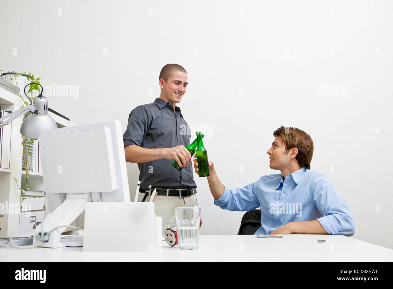 Due colleghi avente una rara festa della birra a lavoro. Foto Stock
