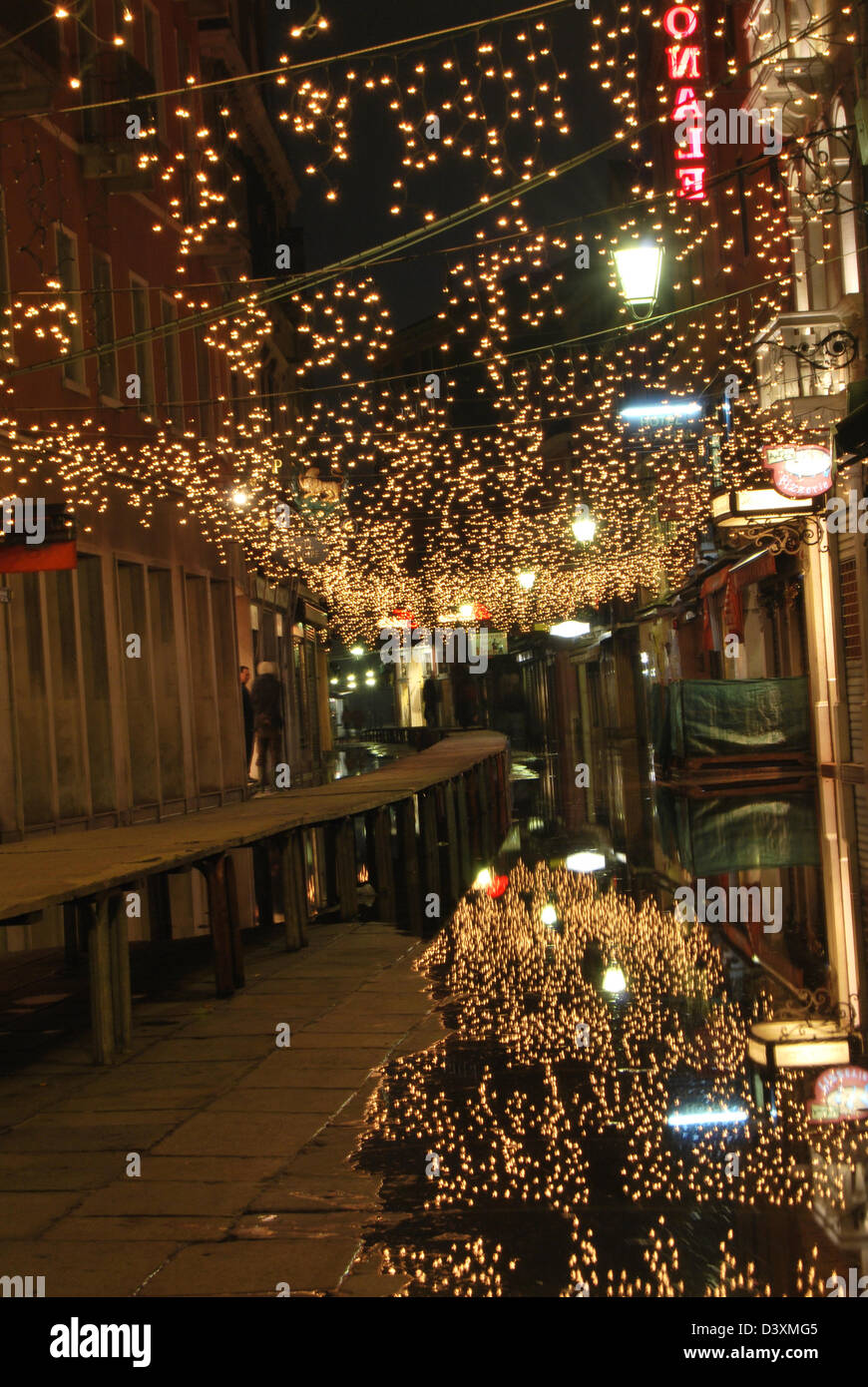 Luci appese sopra una passerella riflettono in alluvioni a Venezia Italia Foto Stock