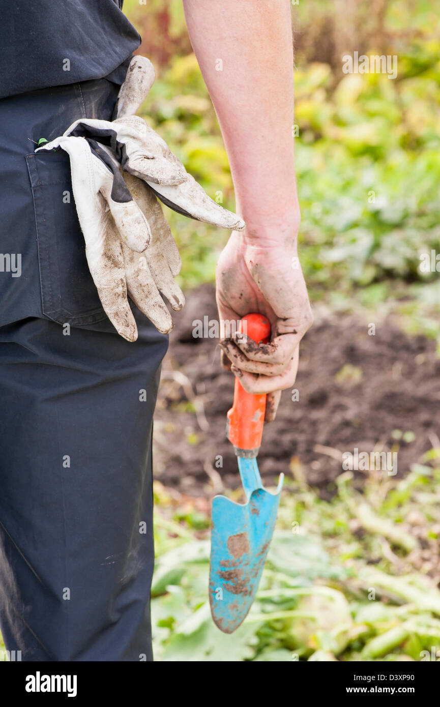 L uomo nel suo giardino a coltivare la terra e per preparare il terreno per una nuova stagione Foto Stock