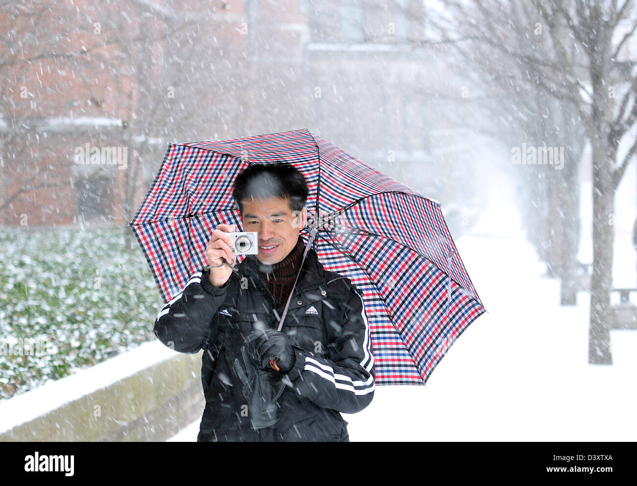 Studente di Yale dalla Cina gode di una tempesta di neve in New Haven CT USA di scattare foto con una fotocamera digitale Foto Stock