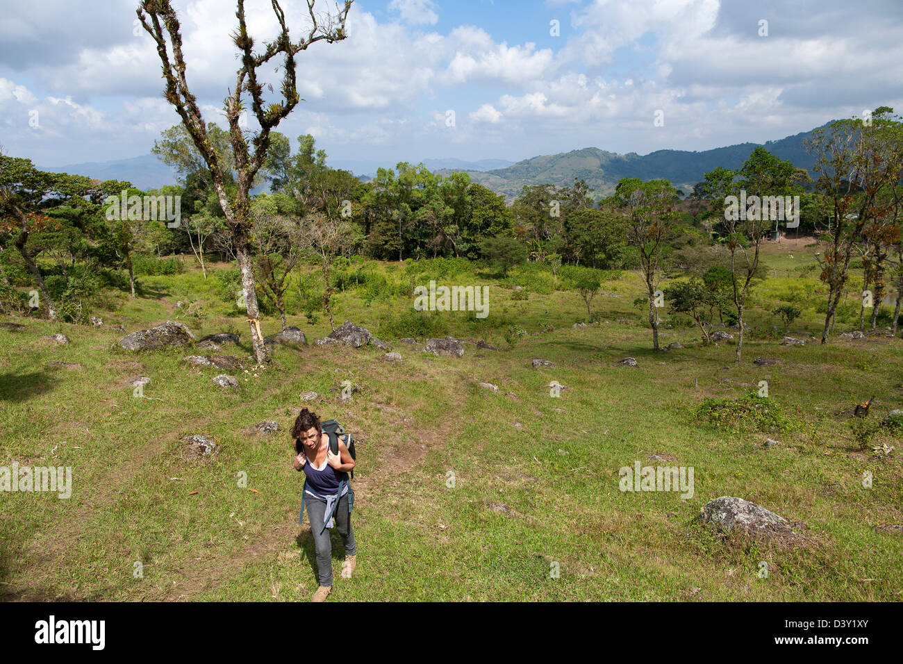 Una donna single travellers escursione attraverso i campi di Miraflores negli altopiani del Nicaragua Foto Stock