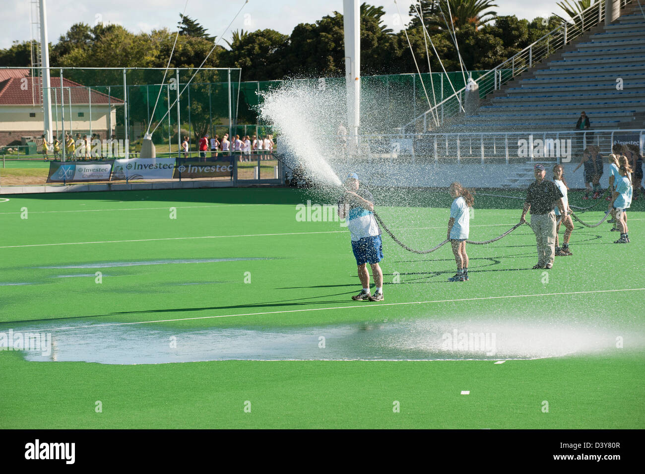 Acqua Groundstaff il passo artificiale a Hartleyvale hockey stadium Città del Capo Sud Africa pitch preparazione di campo Foto Stock