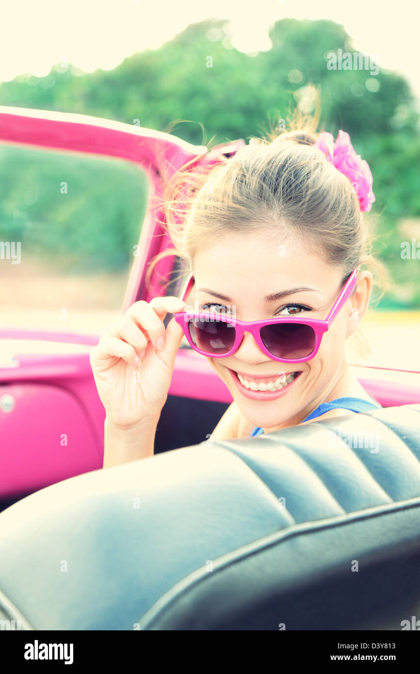Ritratto di donna sorridente in rosa retrò auto sulla strada viaggio durante le vacanze estive Foto Stock