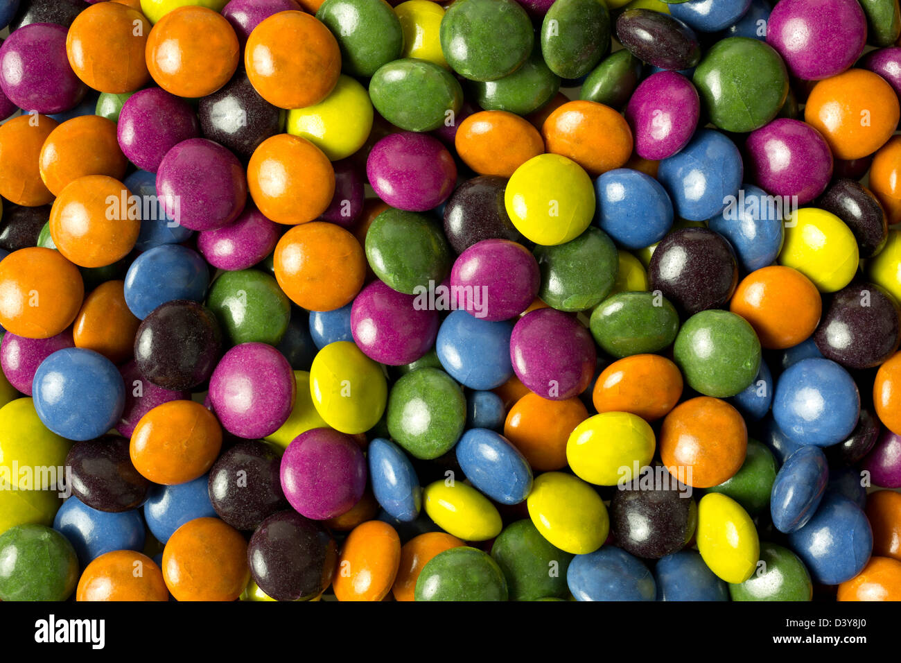 Vista ravvicinata del cioccolato assortiti candy pezzi rivestiti con colori luminosi. Foto Stock