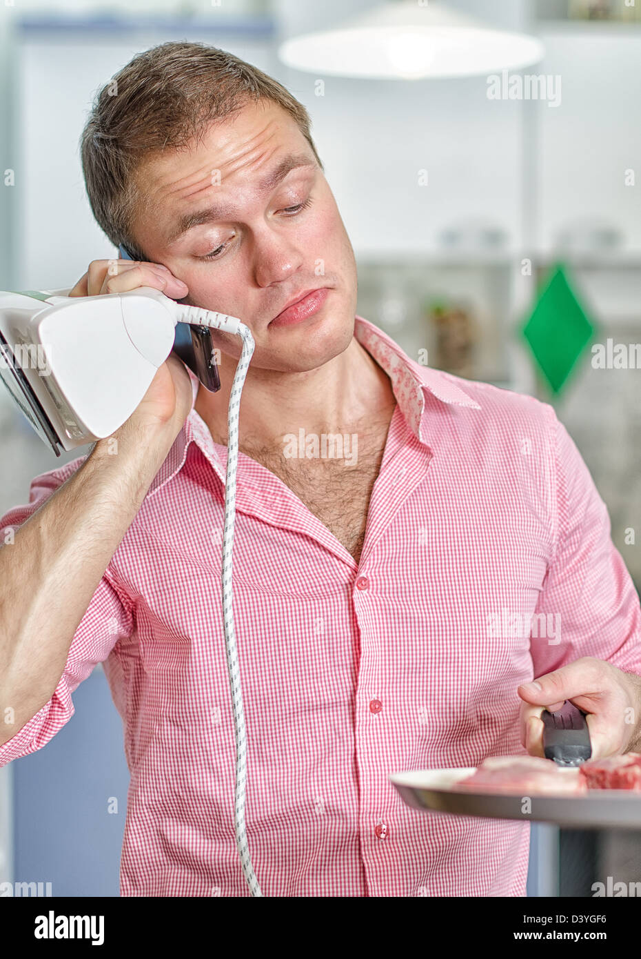 Giovane uomo con pan e ferro che parla al telefono Foto Stock