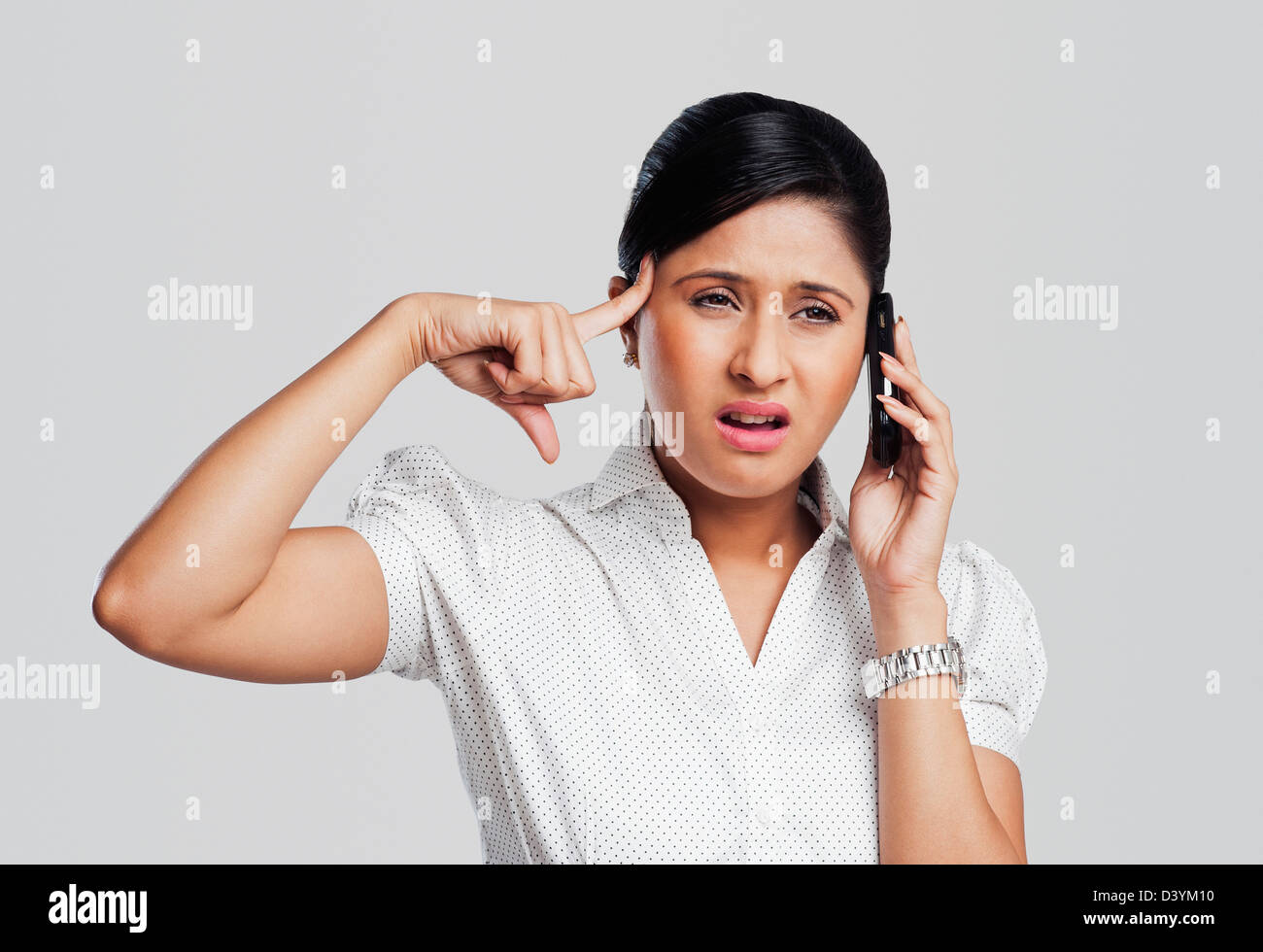 Imprenditrice cercando sconvolto durante la conversazione su un telefono cellulare Foto Stock