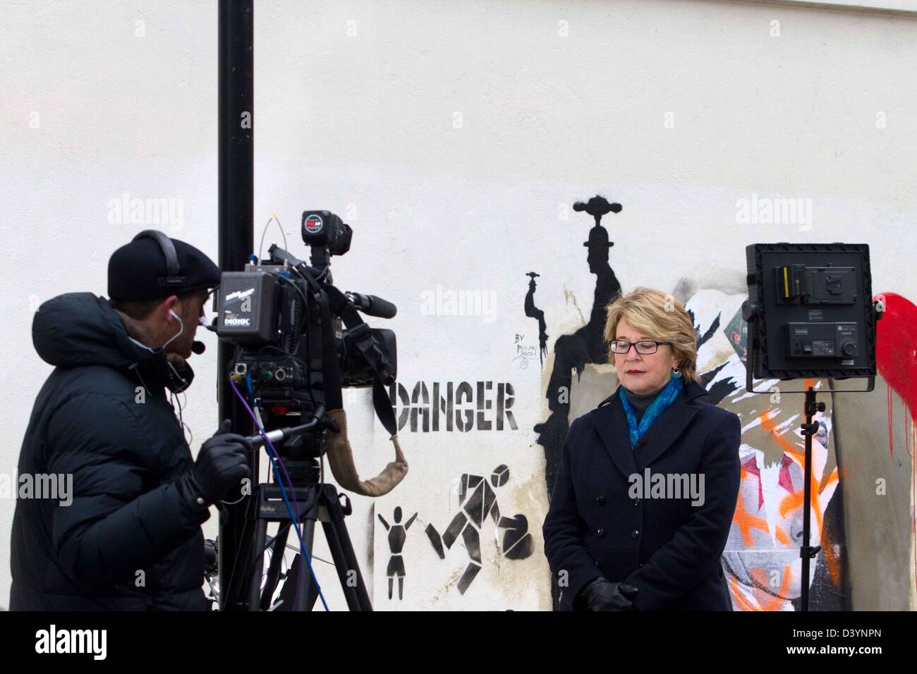 Londra, Regno Unito. Il 25 febbraio 2013. Elizabeth Palmercbs, da CBC telvison facendo una copertura live per il "questa mattina' per il banksy rubato arte dal cancelletto terra del negozio wallprogram a Londra oggi, come graffiti artist Banksy è stato ritirato dalla vendita all'asta dopo una campagna da Londra residenti a recuperarlo, murale che era discutibilmente strappato dalla parete di un North London shop. Credito: fuat akyuz / Alamy Live News Foto Stock