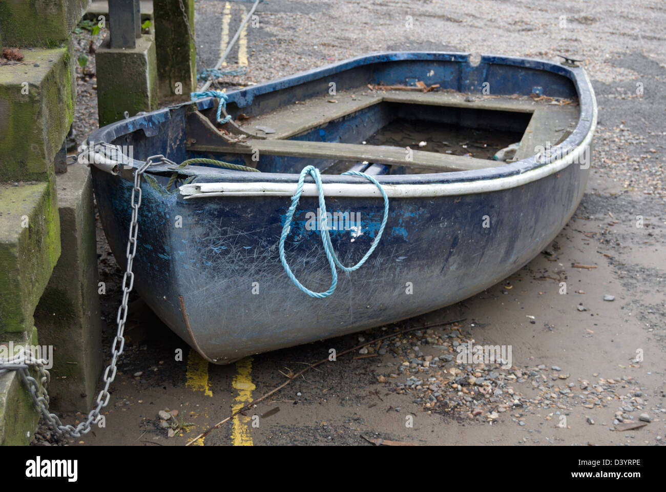 Piccola barca a terra collegato da una catena, parcheggiato di fronte a doppia linea gialla della segnaletica stradale, east twickenham, middlesex, Inghilterra Foto Stock
