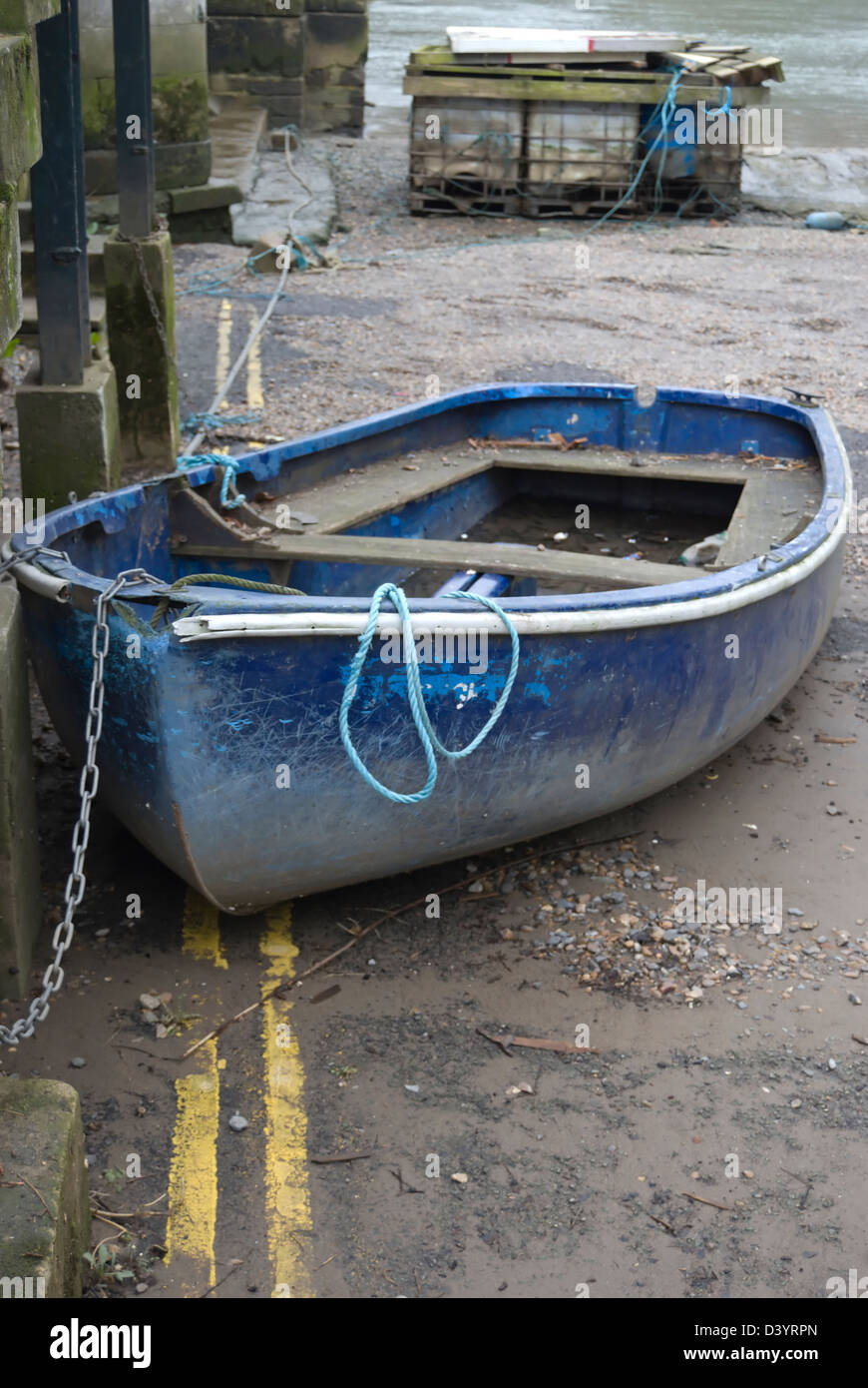 Piccola barca a terra collegato da una catena, parcheggiato di fronte a doppia linea gialla della segnaletica stradale, east twickenham, middlesex, Inghilterra Foto Stock