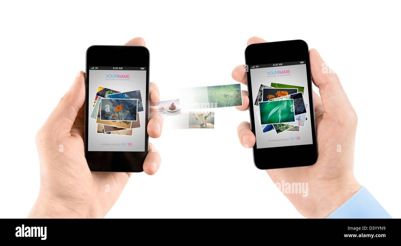 Due mani mobile smartphone mentre è in corso il trasferimento di foto da uno all'altro. Foto Stock