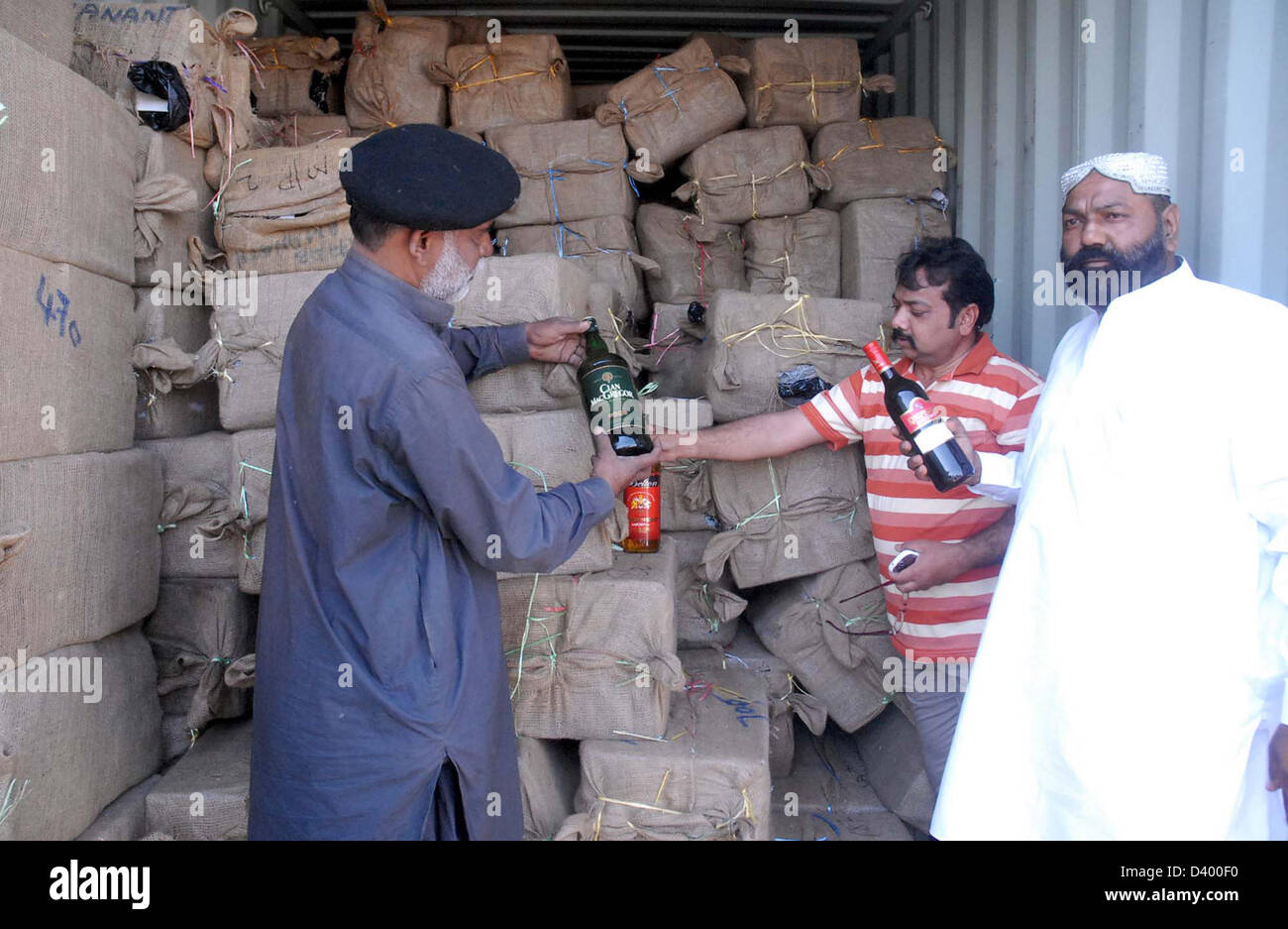 I funzionari doganali mostrano sequestrati illegale di liquori importati bottiglie che sono state recuperate dal Pakistan la sicurezza marittima Agenzia durante anti contrabbando funzionamento su Al Khair barca, durante la conferenza stampa al Ghass Bandar a Karachi il mercoledì 27 febbraio, 2013. Un intelligence basato operazione è stata effettuata in cui il Pakistan la sicurezza marittima Agenzia e Pakistan Intelligence doganale hanno partecipato nella notte il sospetto di una barca Al-Khair fu cacciato e fermati dopo faticosi sforzi alla ricerca della barca recuperata una grande quantità di importazione illegale di liquori 24967 bottiglie, 5 Foto Stock