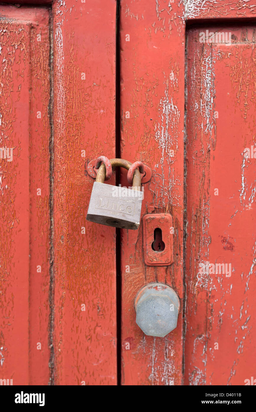 Porta Rossa close up sulla serratura e la maniglia con peeling vernice Foto Stock