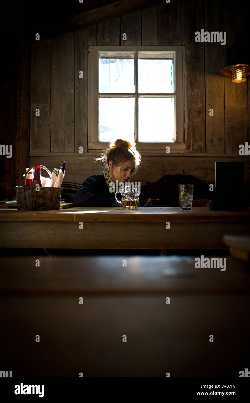 Giovani donne seduta a tavola in pub Foto Stock