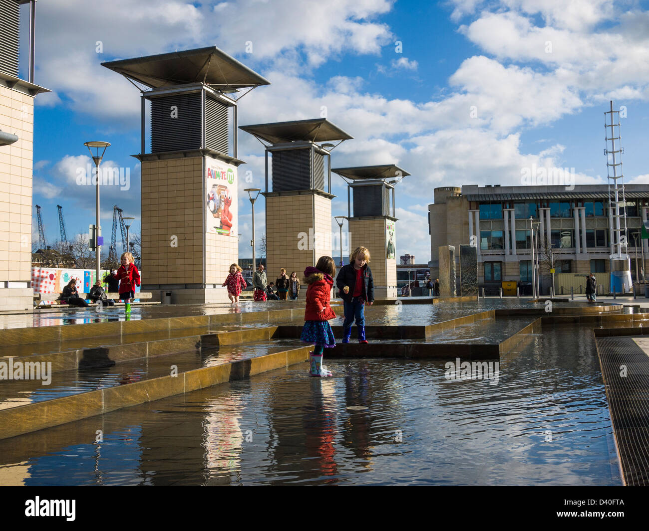 Bambini che giocano con le fontane in Millennium Square, Bristol, Inghilterra. Foto Stock