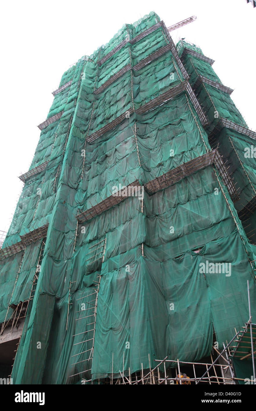 Si tratta di una foto di una torre in costruzione in Hong Kong. Siamo in grado di vedere i ponteggi verde fanno da bambù Foto Stock