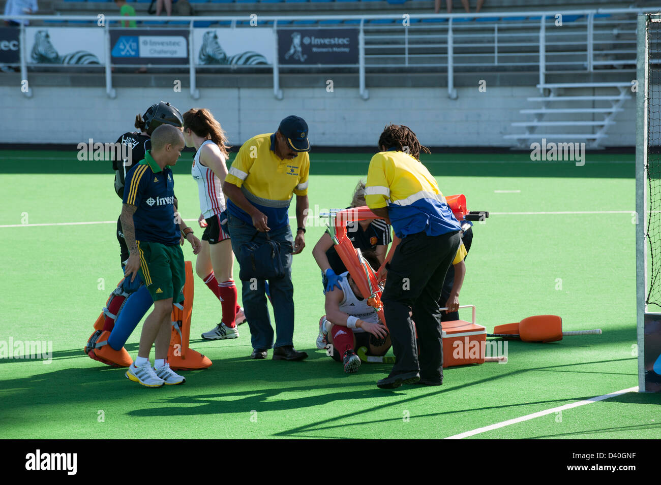 Lesioni sportive hockey femminile player sul terreno dopo essere stato colpito con una mazza da hockey Foto Stock